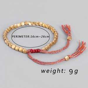 Detalle de pulsera ajustable de cordón trenzado con cuentas de bronce y borlas de colores