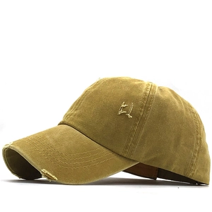 Detail of vintage washed cotton ponytail baseball cap with distressed brim and gold embroidery