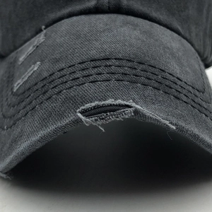 Close-up of distressed washed cotton baseball cap brim with vintage ripped details
