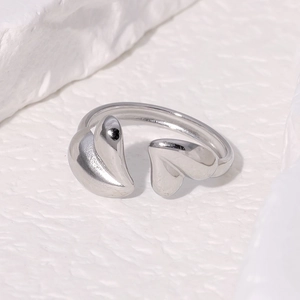 Macro shot of minimalist silver heart open ring on stone base showing polished texture