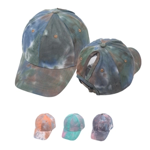 Detail view of tie-dye ponytail baseball caps showing rear hole and multiple color options