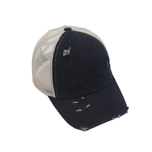 Detail of distressed ponytail baseball cap featuring breathable mesh and frayed denim holes