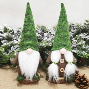 Coppia di gnomi natalizi verde bosco con base in legno su sfondo di pini innevati