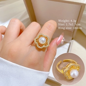 Detail view of gold flower ring featuring pearl accents and sparkling zirconia stones