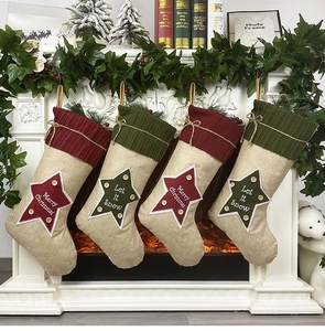 Detailed view of four linen Christmas stockings with red and green cuffs on fireplace