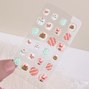 Macro view of Christmas themed kids' fake toenails with Santa and snowflake 3D patterns