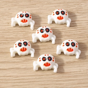 Detail of white plastic spider charms with orange markings for DIY Halloween jewelry