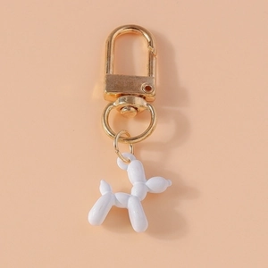 Detail of creative white resin balloon dog keychain with golden lobster clasp and ring