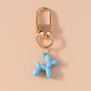 Close-up of blue resin balloon dog keychain with golden U-shaped metal spring clasp