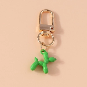 Detail of a bright green balloon dog keychain with a polished gold metal clasp and ring
