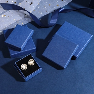 Royal blue textured jewelry gift boxes with earrings on elegant starry tulle background