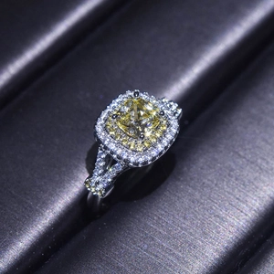 Macro shot of platinum-plated ring with square yellow center stone and halo pave diamonds