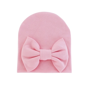 Pink knitted baby hat with a large soft bow decoration for infants aged 0-6 months