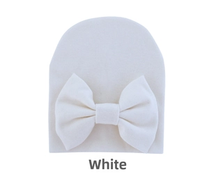 Detailed view of soft white cotton baby hat featuring a large decorative bow
