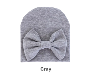 Detail showing the grey soft knit fabric and large decorative bow on the infant beanie