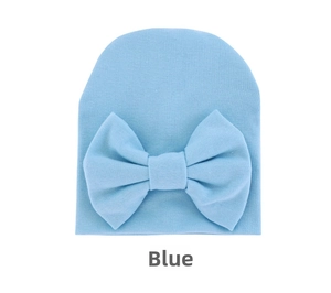 Detail of baby knit hat in light blue with large bow decoration and soft cotton texture