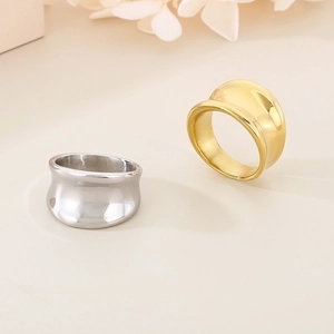Macro shot of minimalist wide irregular titanium steel rings in gold and silver polished finish