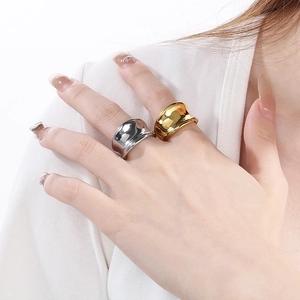 Close-up of irregular liquid metal gold and silver titanium steel rings on a model hand