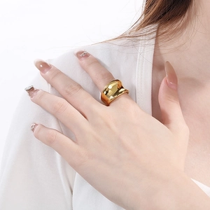 Detail of minimalist wide irregular wave ring with high-polish 18K gold finish