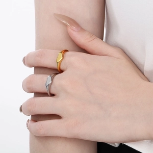 Close-up of minimalist gold and silver organic geometric rings with mirror finish
