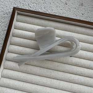 Detail of a large translucent grey resin hair claw clip on a velvet jewelry tray