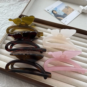 Five-pack of large butterfly hair claws in assorted glossy colors on a display tray