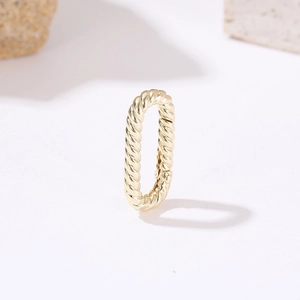 Minimalist gold oval twisted earring with polished woven texture on white background