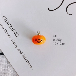 Macro view of a 12x12mm orange resin pumpkin charm for Halloween DIY jewelry making