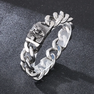 Macro shot of silver lion head buckle on stainless steel Cuban chain bracelet