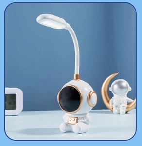 Detail of creative astronaut desk lamp with flexible neck and gold accents for students