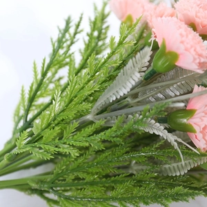 Detail of pink artificial carnation stems and green foliage for home decoration