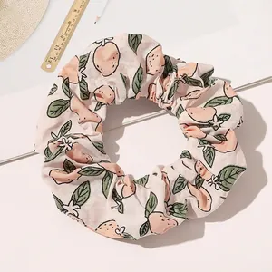 Detail of pink cotton scrunchie with lemon patterns and rustic lifestyle props