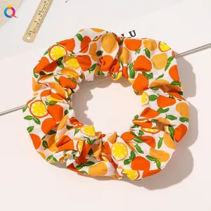 Close-up of a white scrunchie with orange slice patterns and a high-elastic inner band