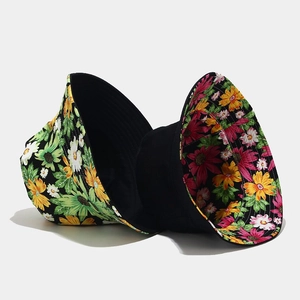 Détail d'un chapeau bob réversible avec des motifs de marguerites colorés sur fond noir
