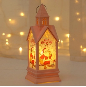 Detail of pink Christmas church lantern with Santa Claus painting and warm glow
