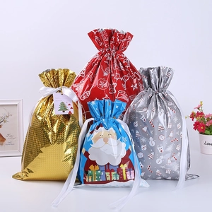 Detail of assorted Christmas drawstring gift bags in metallic red, gold, blue, and silver