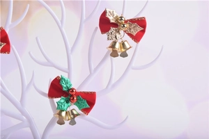 Detail of red Christmas bows with holly leaves and gold bells on white branches