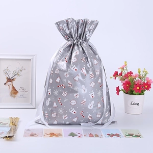Silver Christmas gift bags with festive patterns, including gold ties and holiday cards