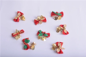 Detail of red Christmas bows with gold bells, green leaves and festive red berries