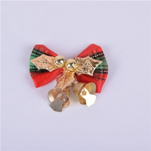 Close-up of red and green plaid Christmas bow with golden bells and holly leaves