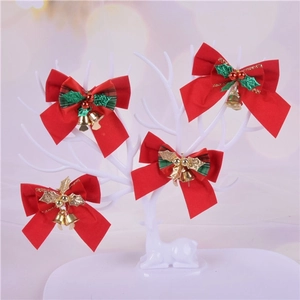 Detail of red Christmas bows with metal bells and holly leaves on a deer antler stand