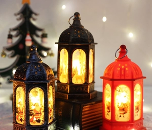 Close-up of vintage Christmas lanterns with Santa and reindeer motifs on old books