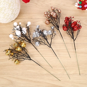 Artificial Christmas berry picks in gold silver red and white on wooden background