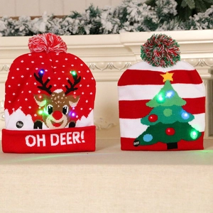 LED knitted Christmas beanies with reindeer and tree patterns on a festive mantle