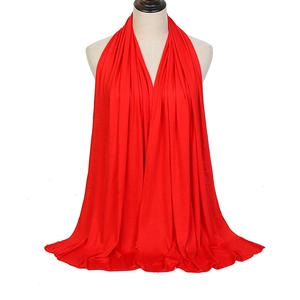 Solid red mercerized cotton scarf with high drape shown on a head mannequin