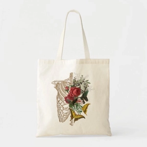 Detail of canvas tote bag with artistic floral rib cage print and butterfly graphics