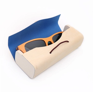 Detail view of foldable wood texture case with orange sunglasses and navy fabric lining
