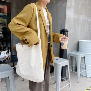 White canvas shoulder bag with daisy floral print styled with a mustard yellow blazer