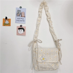 Daisy print canvas crossbody bag with ruffled strap and floral flap closure