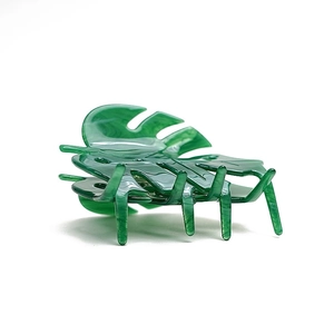 Glossy green monstera leaf hair claw clip in acetate resin on white background